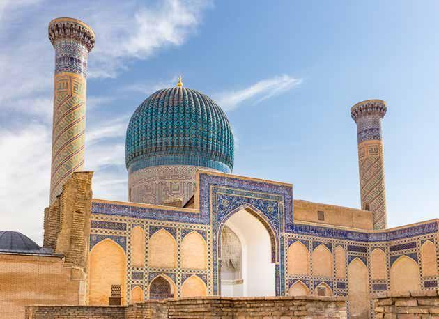 A mosque with a blue dome and a blue sky in the background.