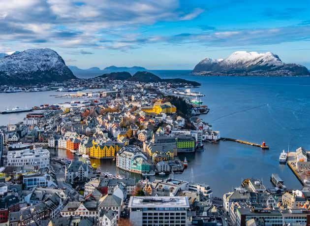 An aerial view of a city surrounded by water and mountains.