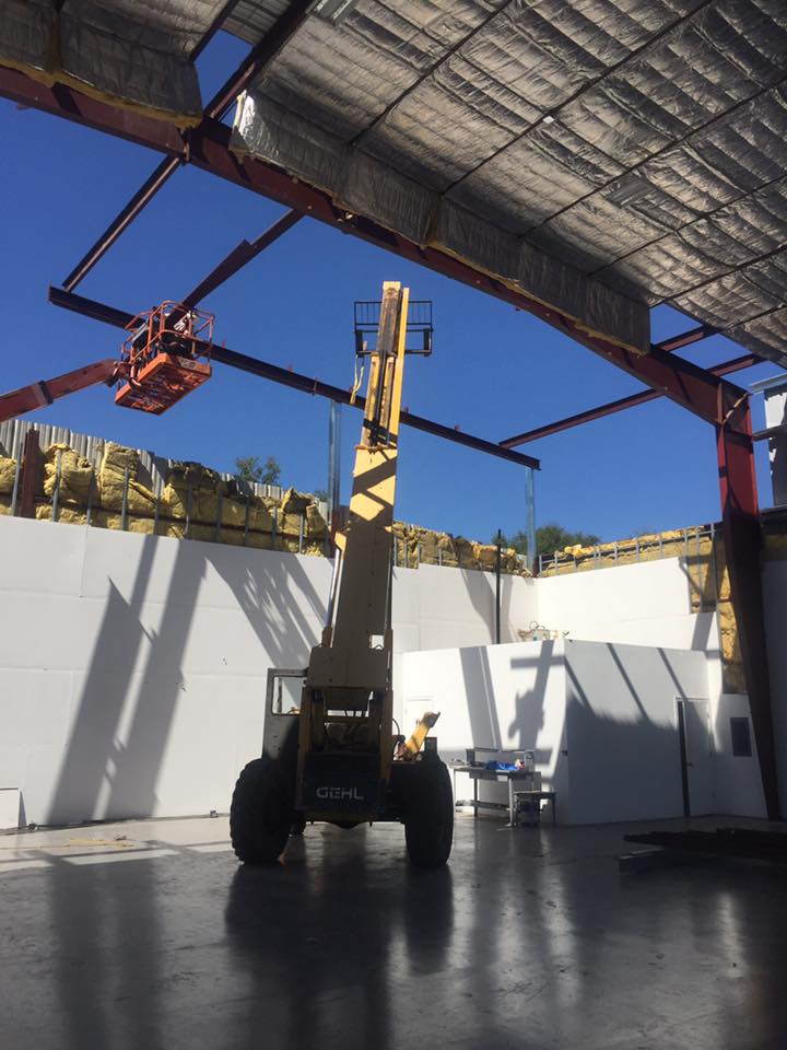 Steel building with cherry picker and crane