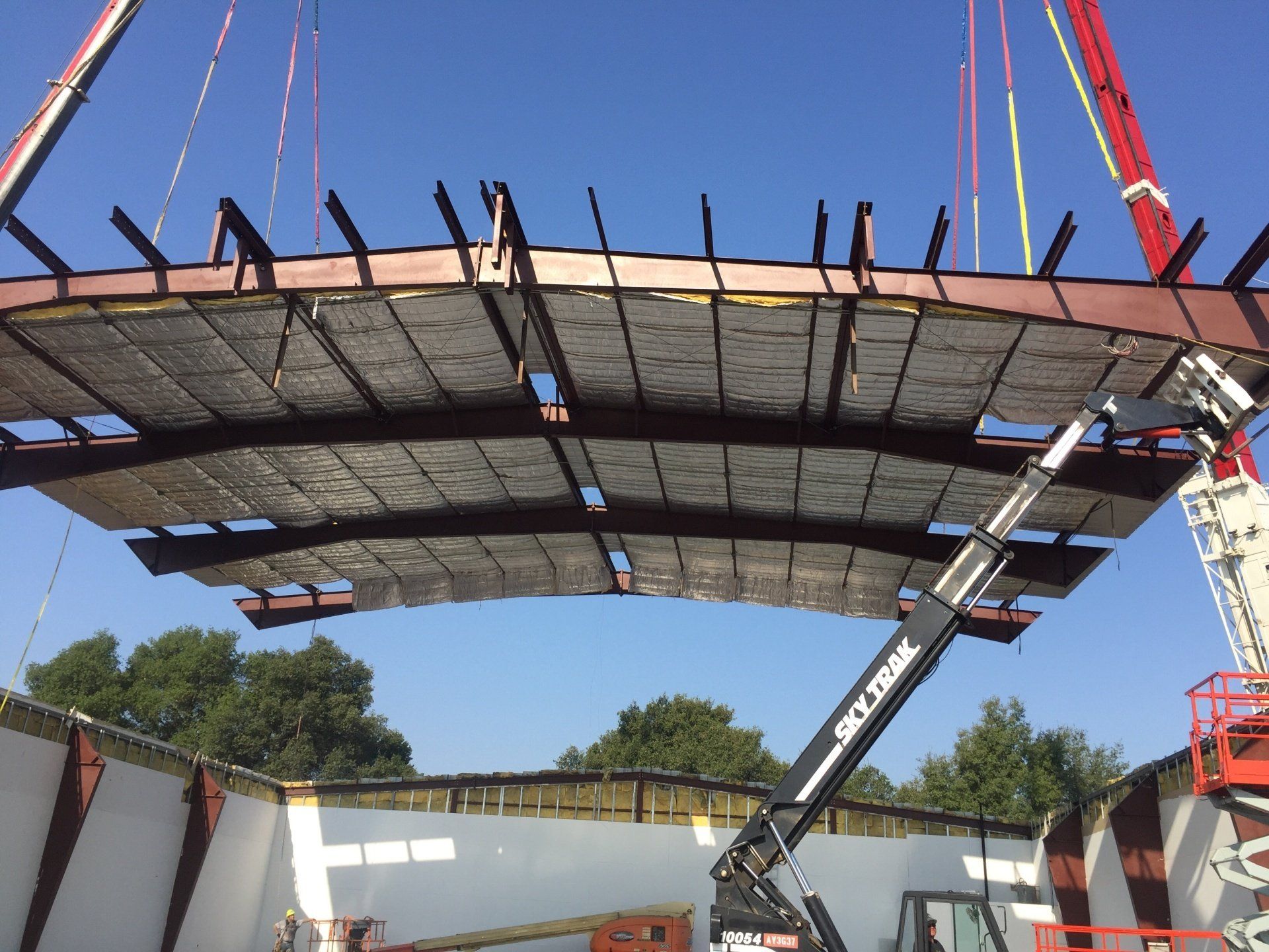 Steel roof  being lowered into position with cranes
