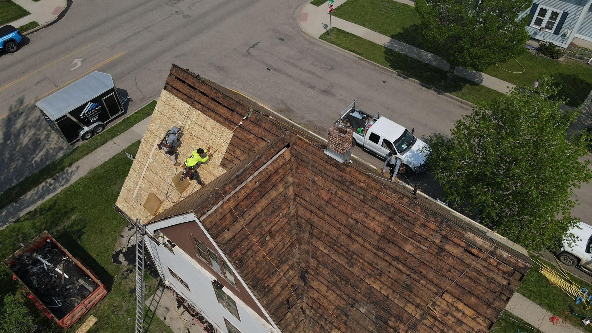 A brick house with a gray roof and white siding