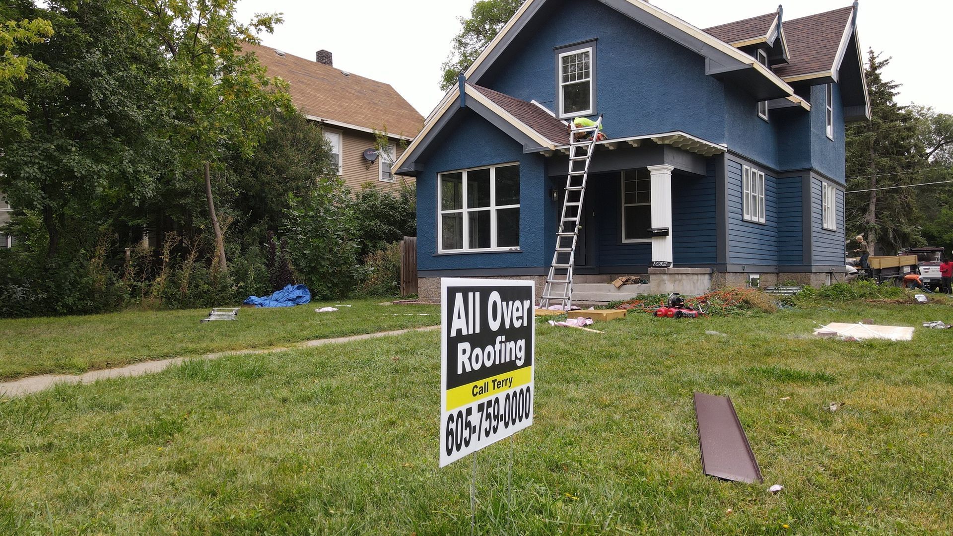 A group of people are standing in front of a truck holding a ribbon.