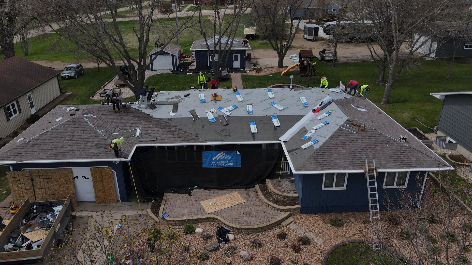 A black chimney on top of a roof with shingles.