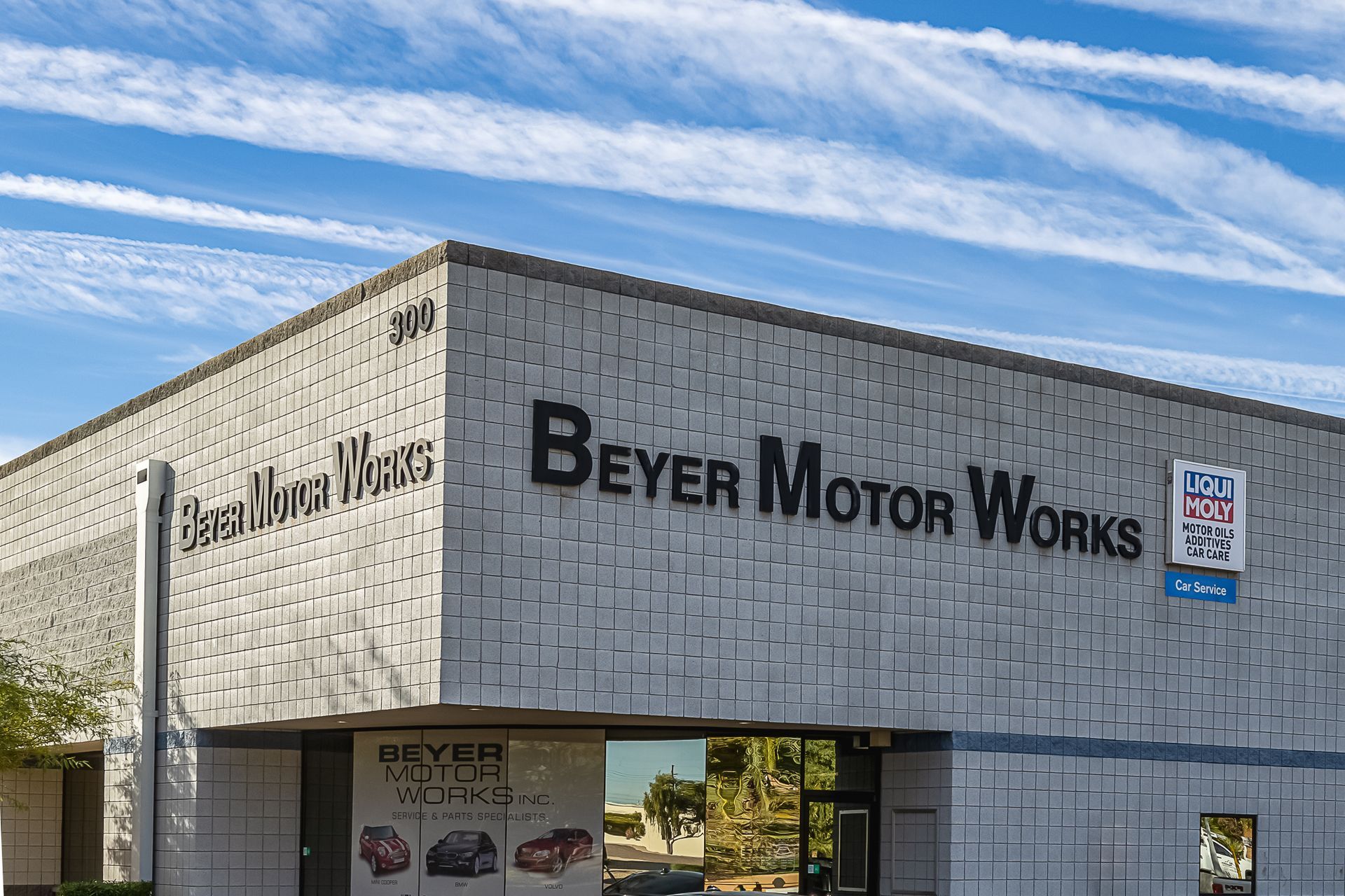 Beyer Motor Works building exterior with sign under a partly cloudy blue sky.