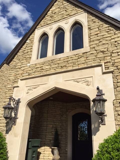 A brick building with arched windows and a black door