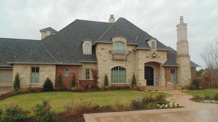 A large brick house with a gray roof and a chimney