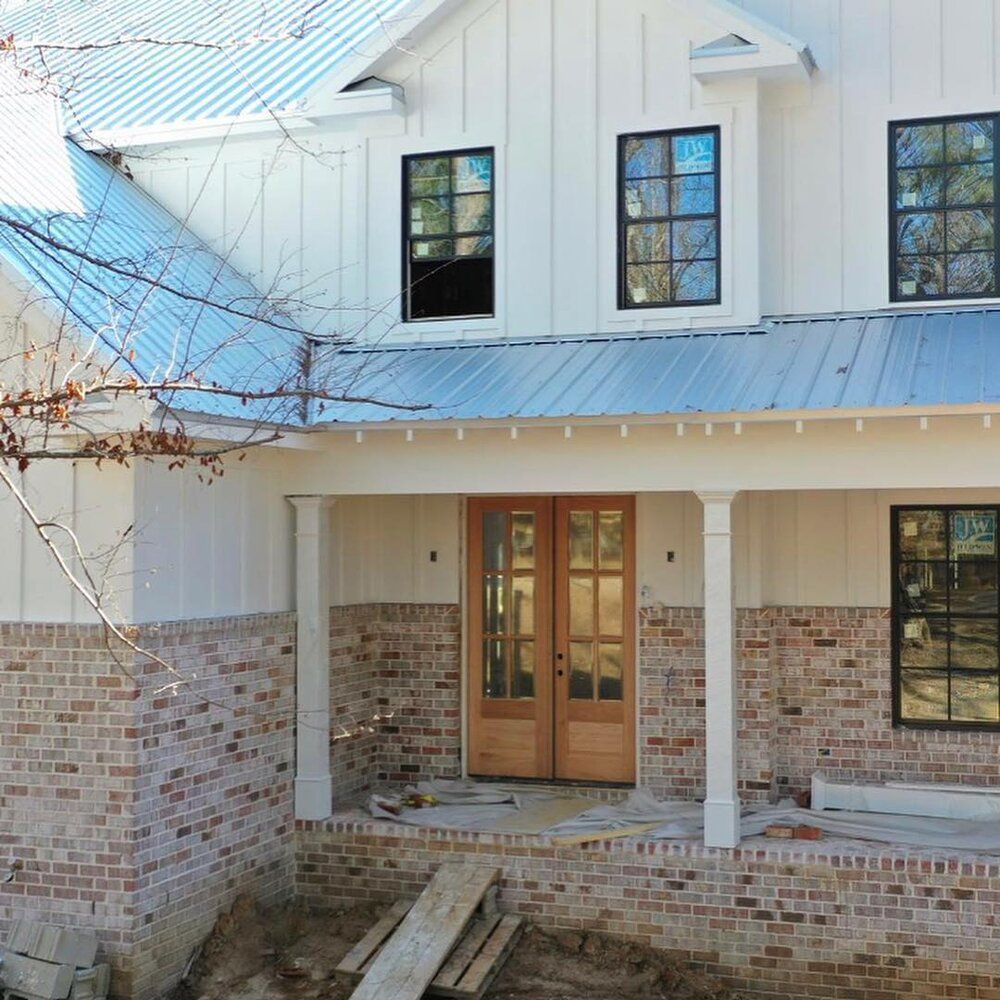A white house with a blue roof is under construction