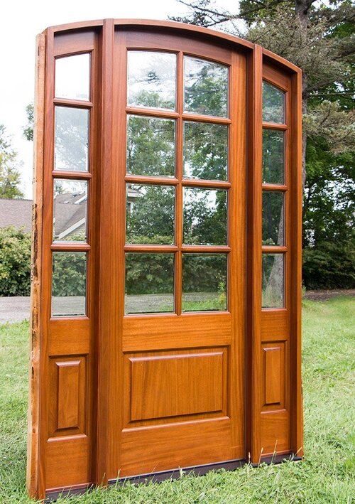 A large wooden door is sitting in the grass