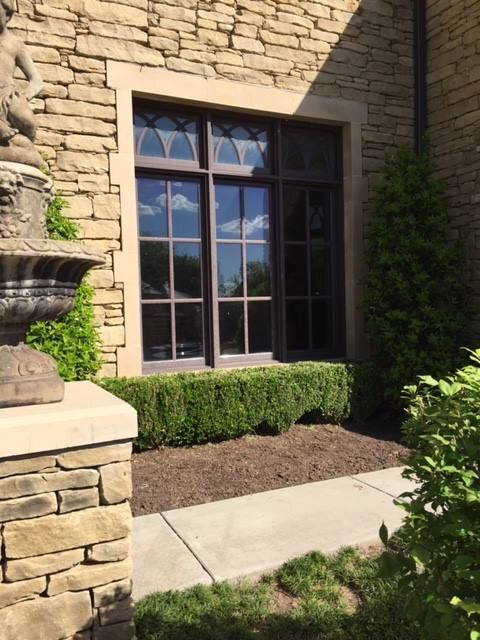 A stone building with a large window and a statue in front of it
