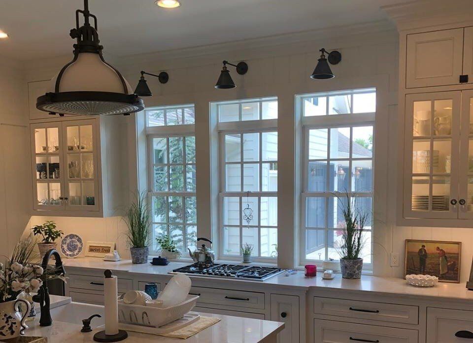 A kitchen with a lot of windows and white cabinets