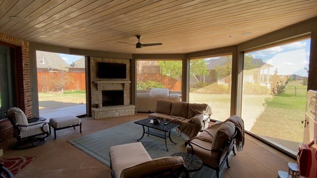 A living room with a lot of windows and furniture.