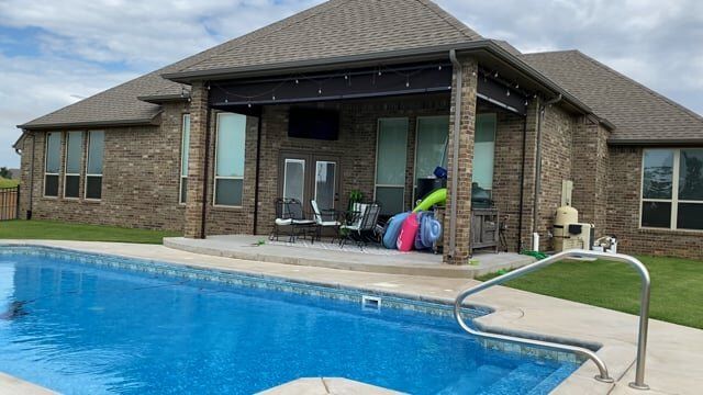 A large house with a swimming pool in front of it.
