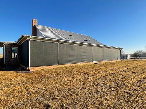 A large house is sitting in the middle of a field.