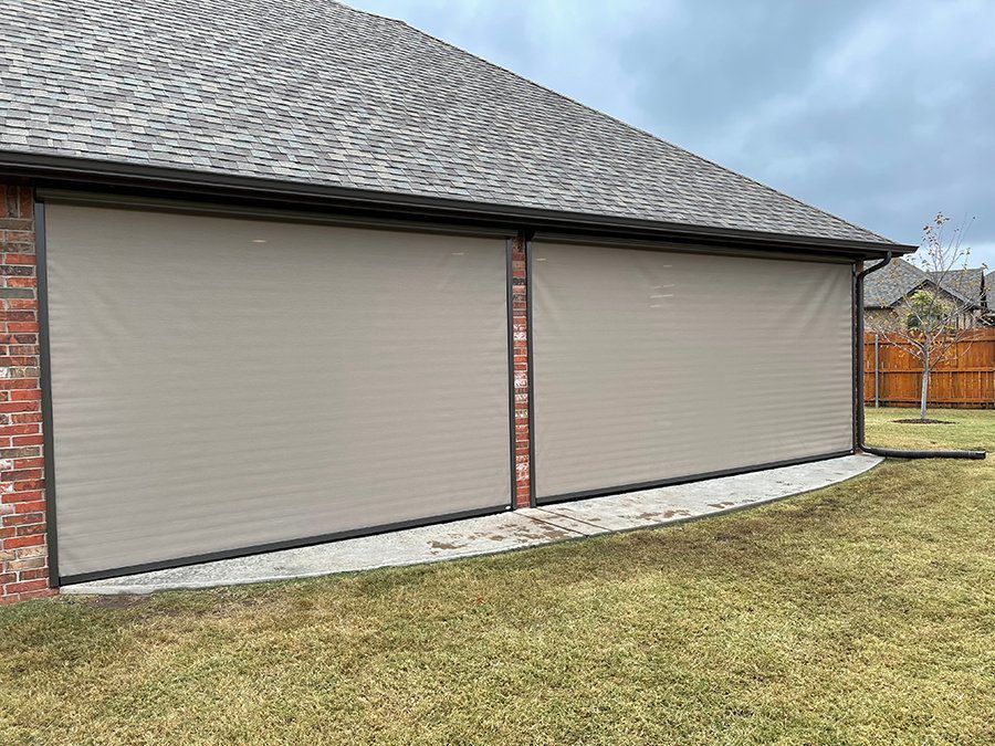 A house with a brick wall and a lawn in front of it.