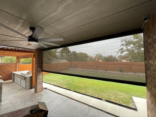 A patio with a ceiling fan and a patio screen.