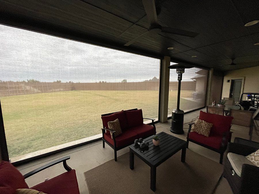 A screened in porch with a view of a field