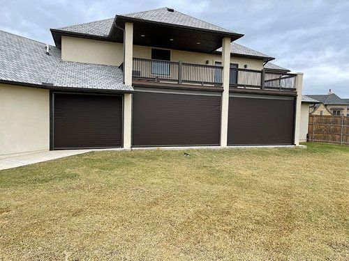 A large house with two garage doors and a balcony.