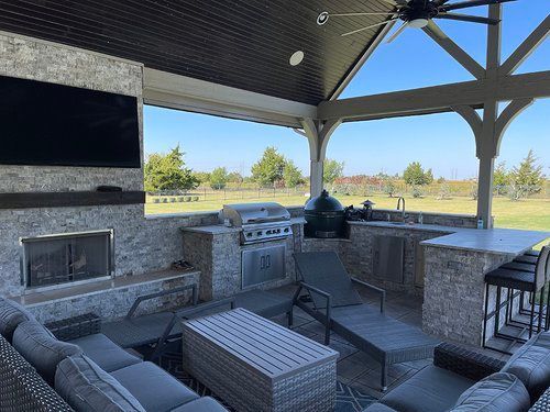 A living room with a couch , table , chairs and a fireplace.