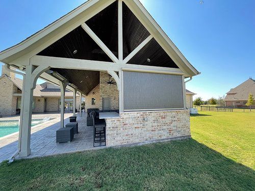 A large house with a patio area and a swimming pool in the backyard.