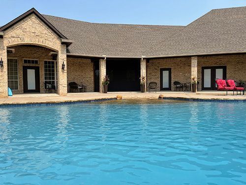 A large house with a large swimming pool in front of it.