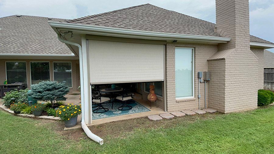 A house with a patio and a screen door on the side of it.
