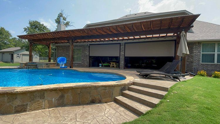 There is a large swimming pool in the backyard of a house.