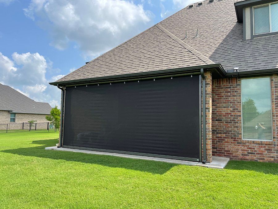 A brick house with a black screen on the side of it.