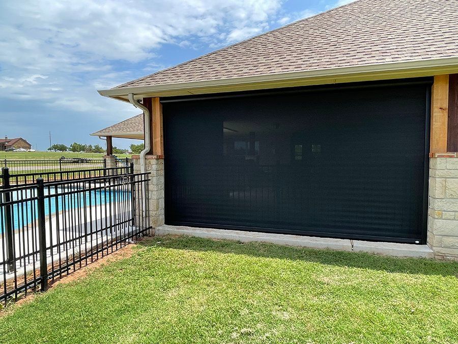 A house with a screened in porch next to a pool.