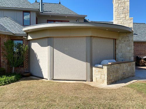 A large house with a curved roof and a brick chimney.