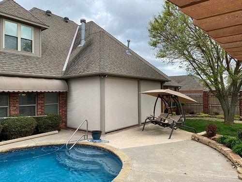 There is a swimming pool in the backyard of a house.