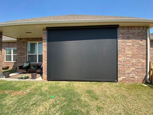 A brick house with a large screen on the side of it.