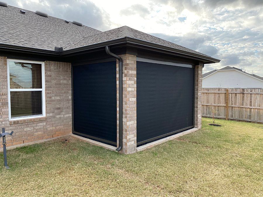 A brick house with a black screen door on the side of it.