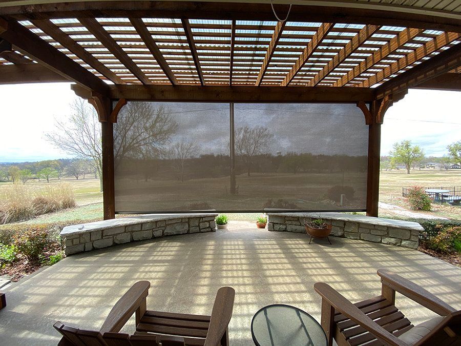 A patio with chairs and a table under a pergola