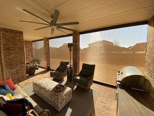 A living room with a couch , chairs , and a ceiling fan.