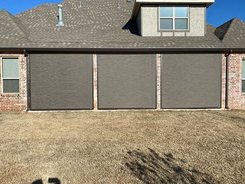 A brick house with a garage door and a lot of windows.