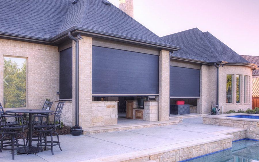A house with a patio and a pool in front of it.