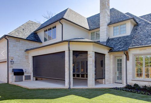 A large white house with a screened in porch and a chimney