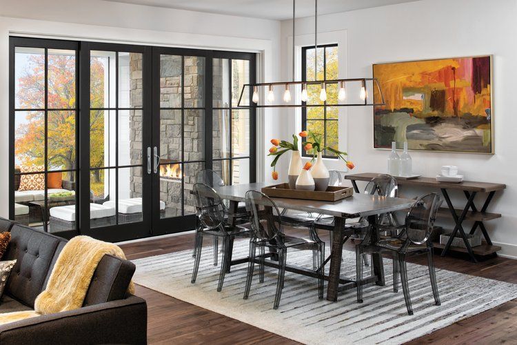 A living room with a dining room table and chairs and a fireplace.