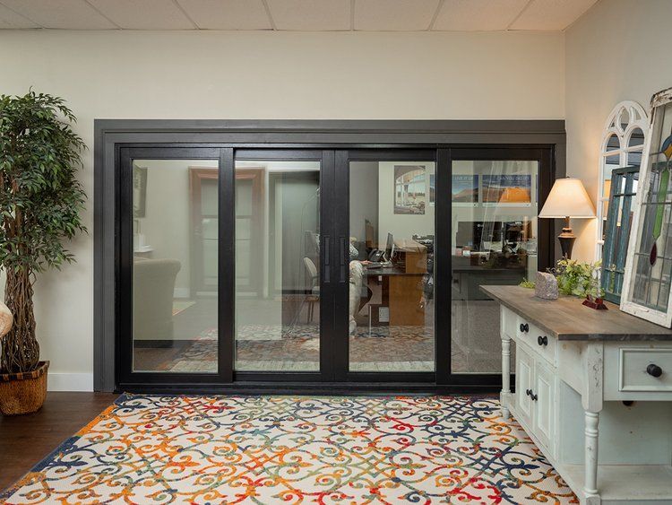 A living room with sliding glass doors and a rug.