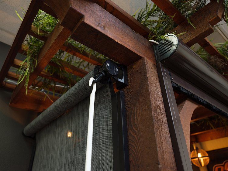 A close up of a roller blind on a wooden pergola