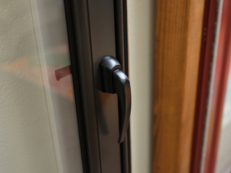 A close up of a black handle on a window.