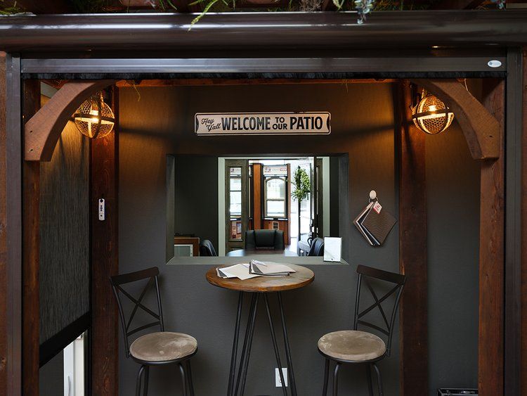 A room with a table and chairs and a sign that says welcome to the patio.
