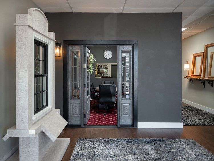 A room with a gray wall and a gray rug