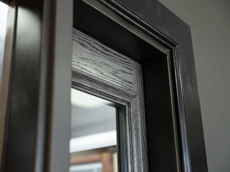 A close up of a black door with a glass window.
