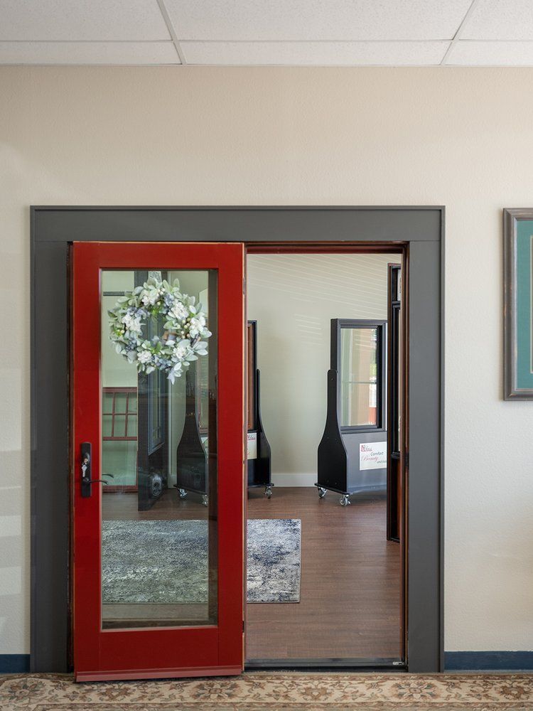 A red door is open to a room with a mirror