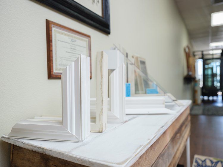 A row of white frames are sitting on top of a wooden table.