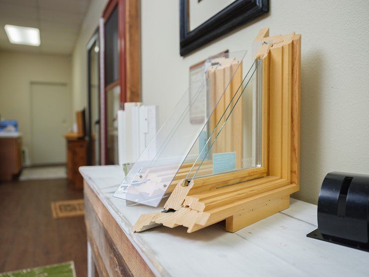 A wooden window frame is sitting on a table in a room.