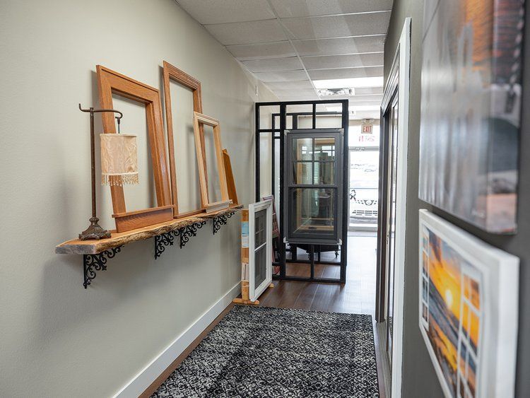 A hallway with a lot of frames hanging on the wall.