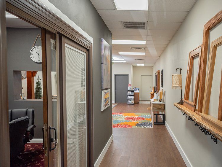 A long hallway with sliding glass doors and a clock on the wall.