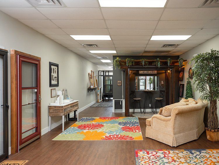 A living room with a couch , chair and rug.